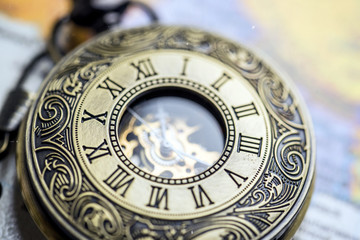 vintage pocket watch on old-fashioned world map background