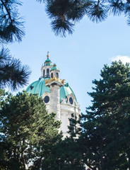A view to a dome of Karlskirche and pine trees at Vienna, Austria.