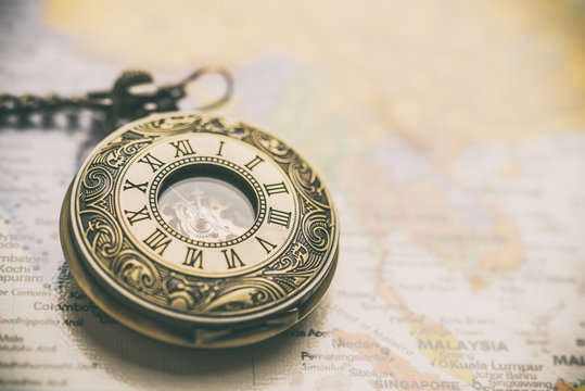 vintage pocket watch on old-fashioned world map background