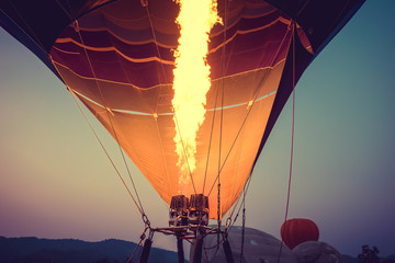 Close-up of Hot Air Balloons with fire at sunset applying retro and vintage filter effect styles.