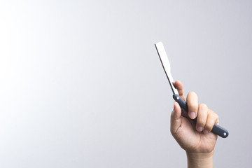 Hand holding razor use in barber