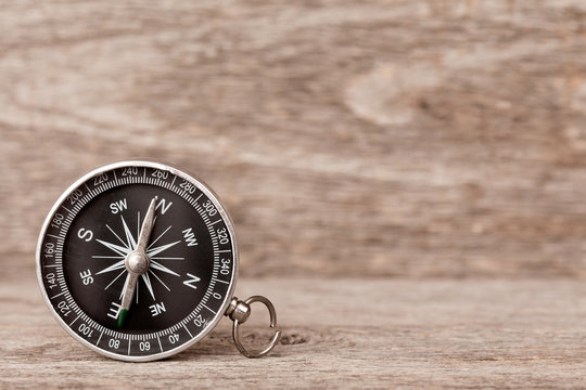 Magnetic compass on a wooden background