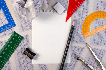 Blank paper reduction on vintage answer sheet with pencil, sharpener and drawing compasses on set of multiple choice answer sheet.