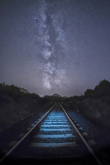 Stunning view of the milky way with a illuminated railroad in the foreground, Sardinia, Italy.