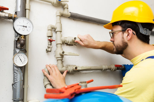 plumber doing maintenance jobs for water and heating systems