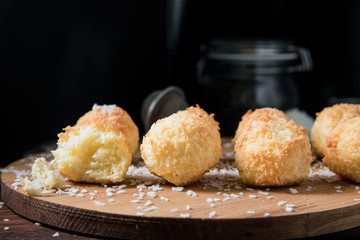Crunchy coconut cookies Congolais on a wooden board against a dark background