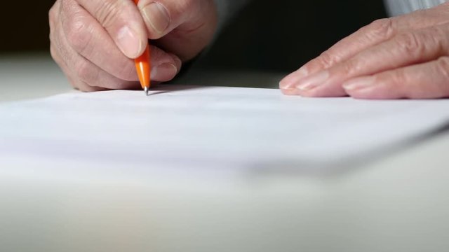 A Man Signs A Paper Document