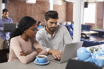 Businessman And Businesswoman At Informal Meeting In Office