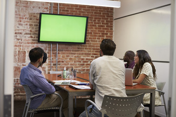 Businesspeople In Meeting Room Looking At Screen