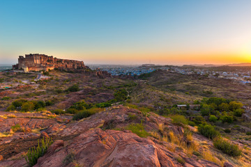 Cityscape at Jodhpur at dusk. The majestic fort perched on top dominating the blue town. Scenic travel destination and famous tourist attraction in Rajasthan, India.