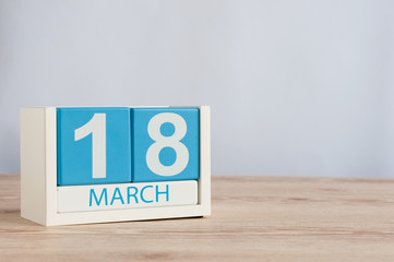 March 18th. Day 18 of month, wooden color calendar on table background. Spring time, empty space for text