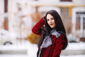 Fototapeta premium Sunny frozen morning of fashionable young woman smiling on winter street full of snow