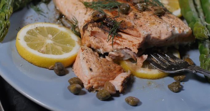 Dolly close up push in view of a delicious roasted organic salmon with capers and dill