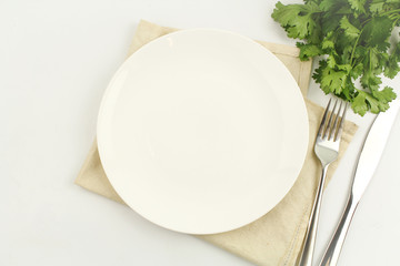 white plate on white background decoration with spoon and fork
