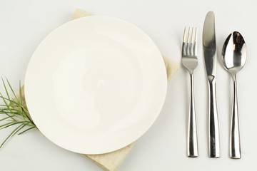 white plate on white background decoration with spoon and fork