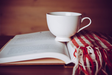 Concept of education - Book with coffee cup,scarf on wooden table . Vintage filter.