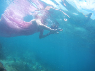 Fototapeta na wymiar Woman floats underwater