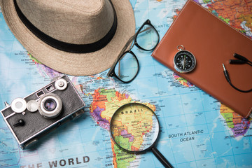 Concept of travel - View of Hipster Traveler accessories and items, Travel and Holiday on world map background vintage tone.