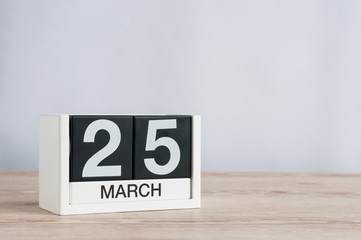 March 25th. Day 25 of month, wooden calendar on light background. Spring time, empty space for text.