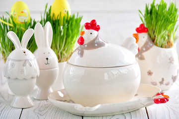 Easter dishes in the form of chickens and rabbits on a white wooden background.