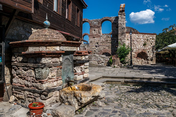 Ancient fountain in the picturesque square in the old town of Nessebar, Bulgaria.