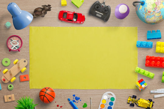 Kid toys play and school education promotion background. Yellow tablecloth surrounded with toys and accessories.