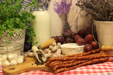 Obraz na płótnie Canvas cheeseboard and sausageboard, pepper, sausage, country. county life, country food, herbs, oregano, milk, grapes, lavender