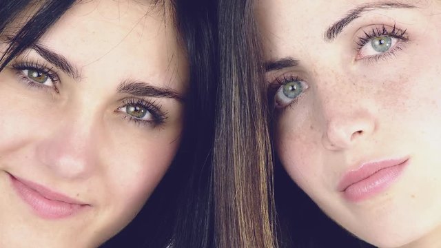 Closeup of two beautiful young women with green eyes smiling