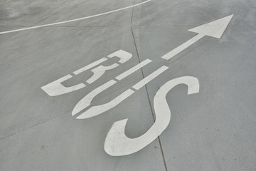 Arrow sign in a parking garage, road marking. Traffic lane intended for buses only.