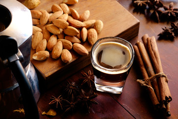 espresso coffee and almonds on wood.