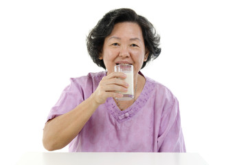 Senior adult woman drinking soy milk