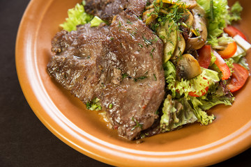 Veal garnished with tomatoes , mushrooms and lettuce