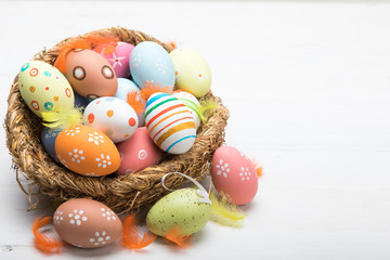 Fototapeta na wymiar Colored Easter eggs in the basket on a white background. Easter background. Easter eggs