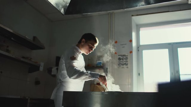 Professional chef man prepare gravy sauce with spices on oven at restaurant kitchen