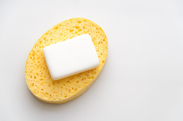 used soap on a yellow sponge placed on a white background with copy space