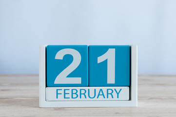 February 21st. Day 21 of month, blue and white calendar on wooden table background. Winter time. Empty space for text