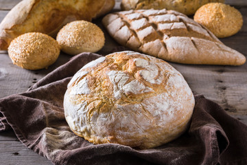 Several types of fresh bread lying on an old wooden table