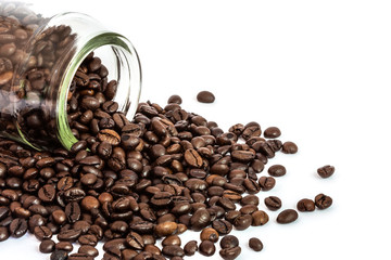 coffee beans spilling out glass bottle on white background 