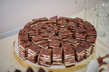 Pieces of chocolate cake with white cream on round dish