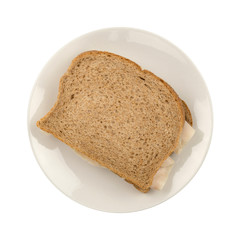 Turkey breast sandwich on wheat bread top view isolated on a white background.