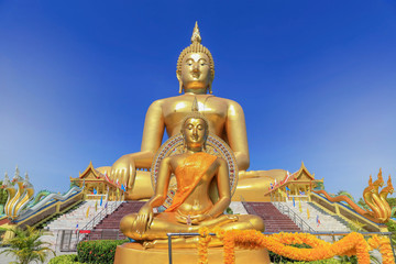   biggest golden buddha statues in wat muang public temple at angthong province, thailand on blue sky background