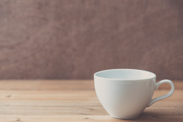 white cup on wooden wall background