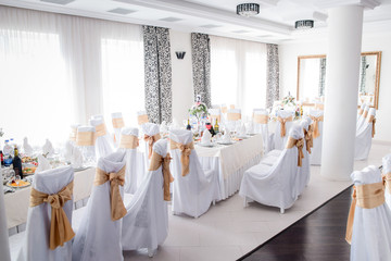 White daylight illuminates cosy restaurant prepared for wedding dinner