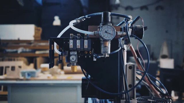 View on compressor gauge of big industrial wood cut machine is moving at work inside woodwork factory