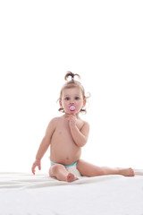 Girl in pampers playing in studio sucking baby nipple.