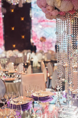 Crystal chains hang from the pink centrepiece on dinner table