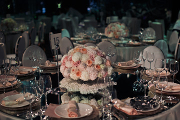 Round cetrepiece and card with number 15 stand in the middle of mirror dinner table