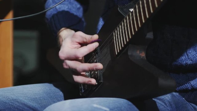 4k musician in the studio playing the electric guitar mediator, close up