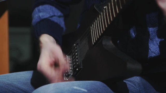 4k musician in the studio playing the electric guitar mediator, close up, rock'n'roll