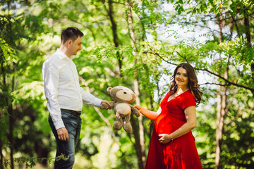 The husband  with pregnant wife keep a toy